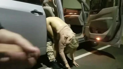 Dos personas tienen sexo con una rubia en un estacionamiento